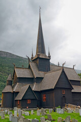 Fototapeta na wymiar View of medieval wooden stave church at cloudy day. Lom, Norway.