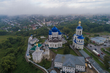 Top view of the temples of the Holy Bogolyubsky nunnery on a foggy August morning (aerial photography). Bogolyubovo, Vladimir region. Russia