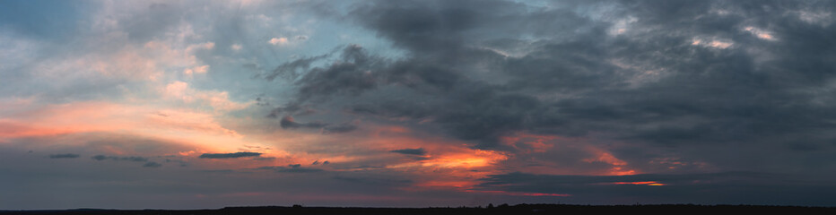 Fototapeta na wymiar Dark sunset with gloomy clouds and red light on the horizon