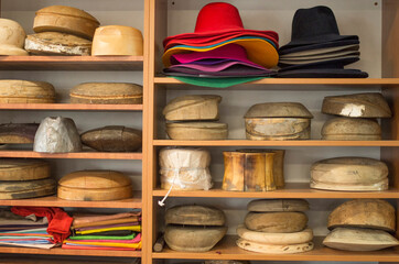 Wooden hat blocks for felt hats and felt hats in workshop - obrazy, fototapety, plakaty