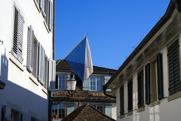 Fototapeta na wymiar Alley Schipfe at the old town of Zurich with flag of canton and city Zurich. Photo taken April 21st, 2021, Zurich, Switzerland.