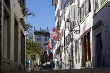 Alley at the old town of Zurich (Schipfe) with Swiss flags in the morning. Photo taken April 21st, 2021, Zurich, Switzerland.