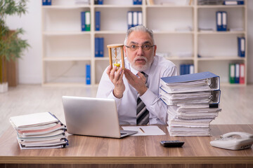 Aged male employee in time management concept