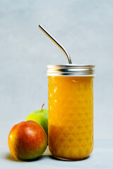 Fresh apple juice in glass with metal straw. Dietary beverage, healthy eating and dieting concept. Fresh-squeezed apple juice with pulp.