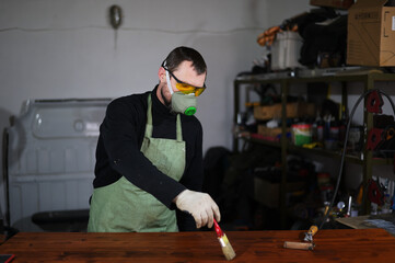 Photo of a man painter working in a workshop