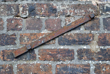 Old Textured Brick Wall with Close Up of Rusty Iron Reinforcing Bar