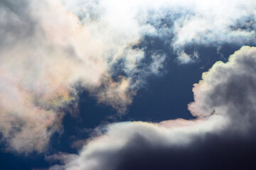 White clouds with iridescence against the blue sky