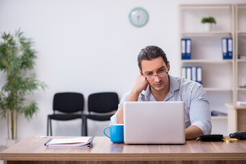 Young male bookkeeper working in the office