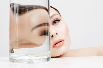 beautiful girl behind the glass with water