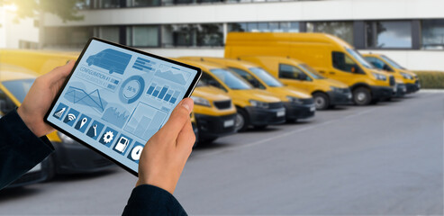 Manager with a digital tablet on the background of vans. Fleet management	