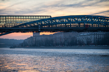 View of the frozen Moskva River on a winter evening at sunset. evening landscape moscow winter. View of the bridge and Moscow street in the evening. reflection of a sunset in a frozen river