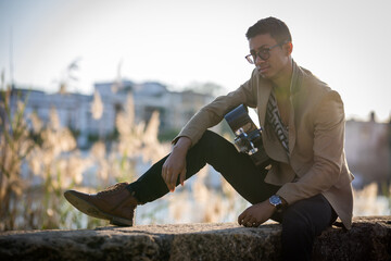 Latin man guitarist posing on the street during sunset against light