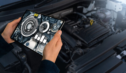 Serviceman repairing a car using augmented reality application.	
