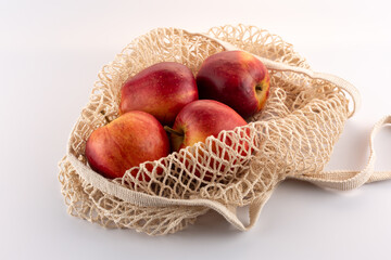 red apples in an eco bag on a white background