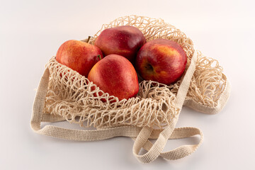 red apples in an eco bag on a white background