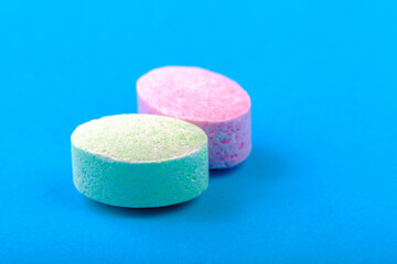 Simple powdered oval shaped unwrapped candies, sweets, colored powder candy macro, extreme closeup Tasty plain powdery sweets, candies detail minimalistic shot, object up close blue background, nobody