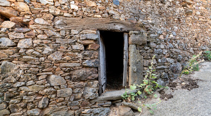 Antique dark entrance with wooden frame and stone wall