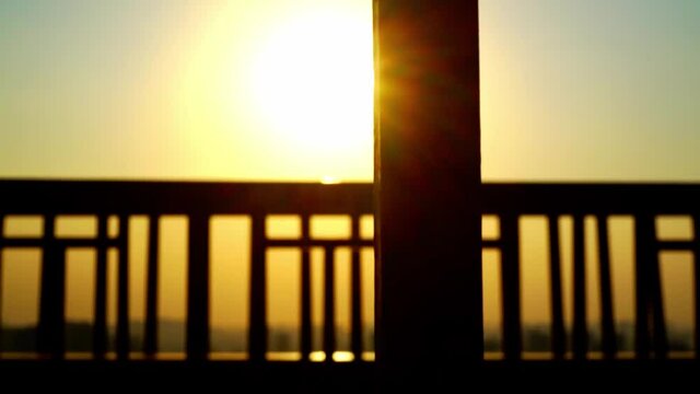 Scorching sun shining on a railing of the bridge. Panning leftward