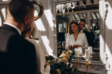 The groom hugs the bride in front of the mirror. Wedding preparations.