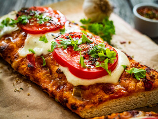 Focaccia - roasted sandwiches with mozzarella and  tomatoes on wooden background
