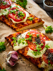 Focaccia - roasted sandwiches with mozzarella and  tomatoes on wooden background
