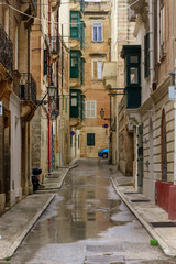 Fototapeta na wymiar Beautiful Malta capital Valleta city street view on rainy cloudy day, wet road