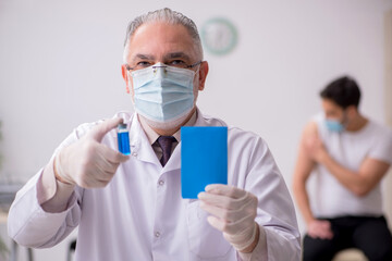 Young male patient visiting old male doctor in vaccination conce