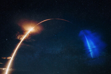 Modern rocket launches a satellite into orbit. Spaceship with blast flies on the starry sky