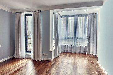 Empty blue room interior with light curtains and parquet floor