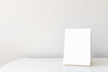 Mock up Label the blank menu frame in Bar restaurant. Stand for booklet with white sheet paper acrylic tent card on table wiht blurred background can inserting the text or picture.