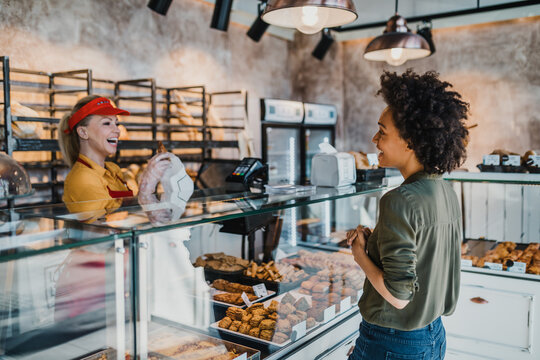 Middle-aged African American Woman Buying Fresh Bread In Bakery.