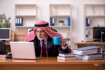 Aged arab businessman employee drinking coffee during break