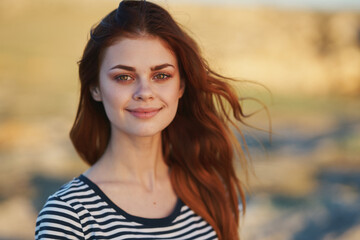 Fototapeta premium happy woman in striped t-shirt smiling in the mountains outdoors