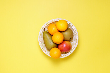 Basket of fresh pears, tangerines, apples fruits. Healthy eating and dieting concept. copy space