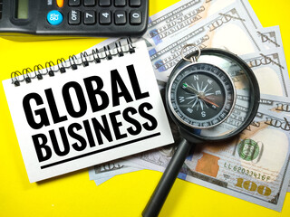 Selective focus of calculator,banknote,compass and magnifying glass with text GLOBAL BUSINESS on yellow background.Business concept.