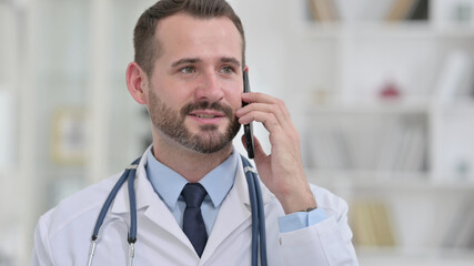 Portrait of Cheerful Male Doctor Talking on Phone