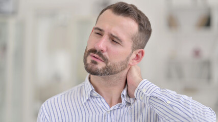 Portrait of Tired Young Man having Neck Pain