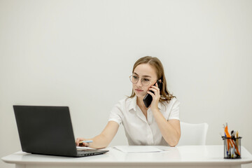 Close-up portrait of a young confident female office manager at her workplace, ready for doing business task.