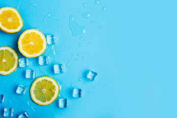 juicy fresh yellow lemon slices and ice cubes on a blue background. Top view, flat lay