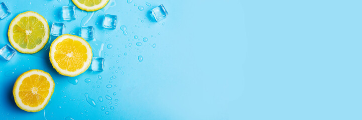 juicy fresh lemon slices and ice cubes on a blue background. Top view, flat lay. Banner