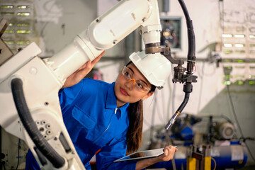 Woman mechanic repairing a robot machine.