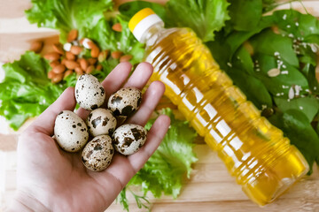 quail eggs in the hands of a girl on a background of fresh greens, farm eco-friendly products for a healthy diet