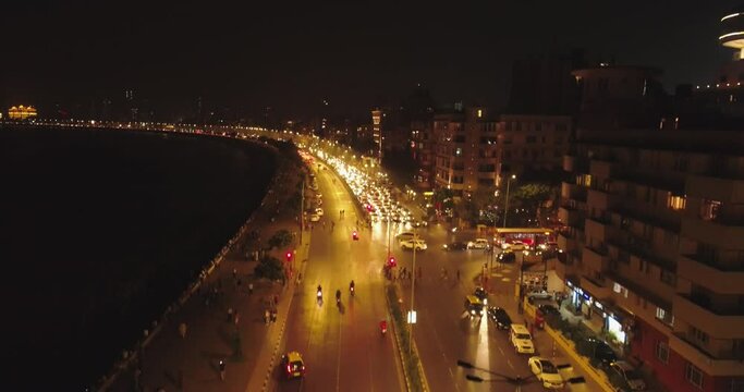 An aerial view with cinematic drone movement of the iconic Marine Drive nightlife with Air India and Trident Hotel buildings in sight.