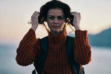 pretty woman in red sweater mountains outdoors portrait close-up and backpack on the back