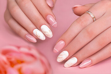 Beautiful female hands with luxury manicure nails, pink and white gel polish
