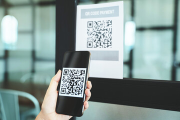 Online money, Close up hand holding smart phone for scanning Qr code for digital payment..