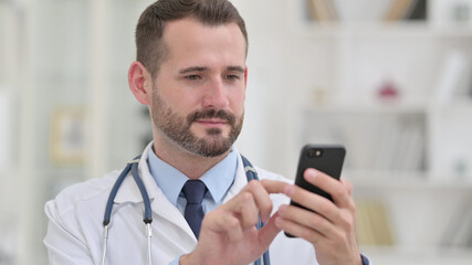 Portrait of Serious Male Doctor using Smartphone 