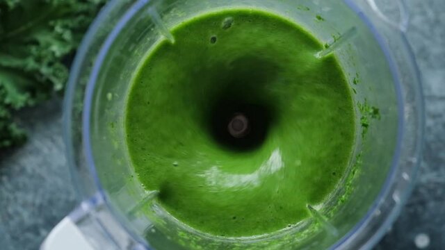Detox green smoothie blending process. Weight loss, fitness food menu concept. Slow motion mixing green monster smoothie