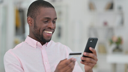 Obraz na płótnie Canvas Portrait of African Man Doing Online Payment on Smartphone 