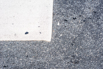 Old asphalt on the road. Marking on a pedestrian crossing. City environment. Top view close up.